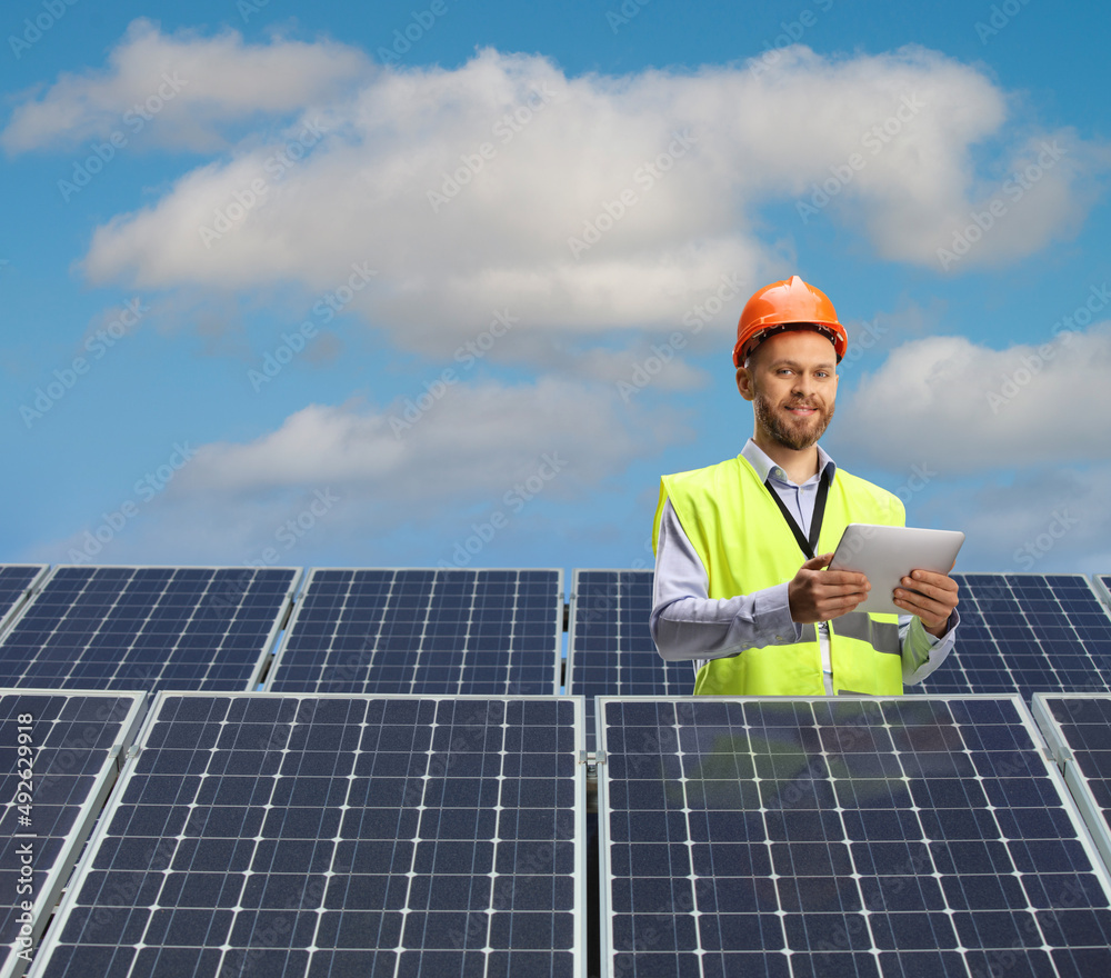 Engineer using a digital tablet on a roof with photovoltaic panels Engineer using a digital tablet on a roof with photovoltaic panels