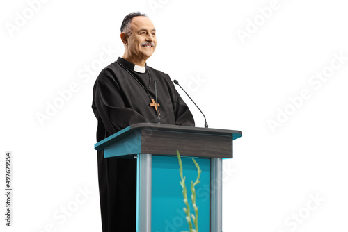 Mature priest giving a speech on a podium photo