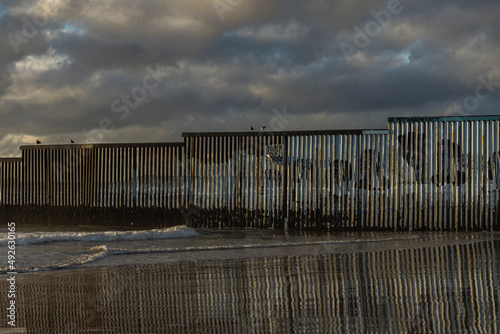Muro fronterizo entre mexico y estados unidos de america, playa con muro, indocumentados. photo