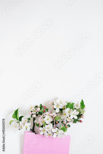 Apple tree flowers in a shopping bag on a white background with copy space. Top view and flat lay. The concept of spring discounts in stores.