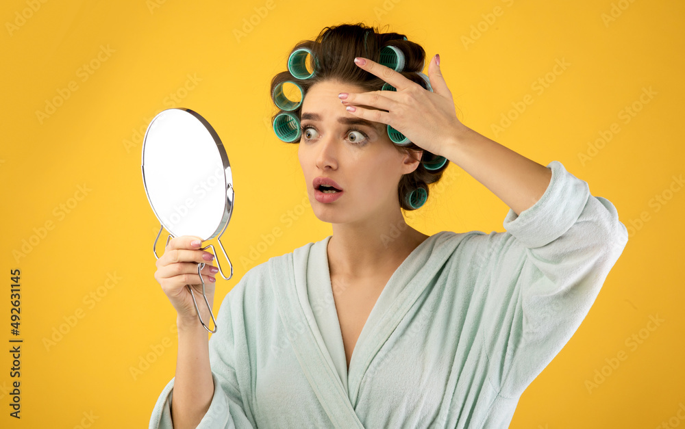 Lady Touching Face Looking At Wrinkles In Mirror, Yellow Background Lady Touching Face Looking At Wrinkles In Mirror, Yellow Background
