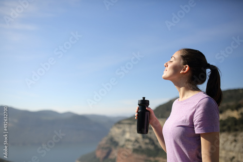Sportswoman drinking after sport in nature