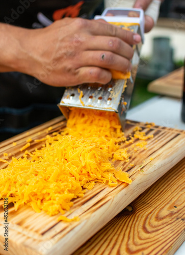 queso cheddar amarillo rallado y agregado en sarten para preparar salsa de quesoqueso cheddarquesocheddar 