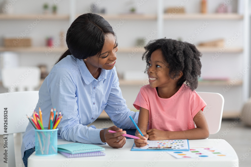 Cheerful african american teacher and little girl exercising Cheerful african american teacher and little girl exercising