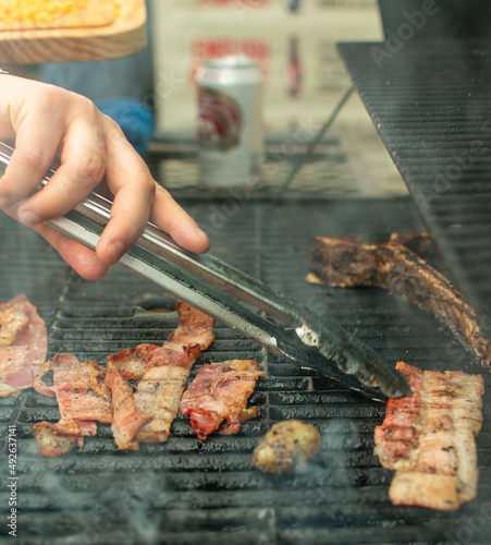 tocino.

tiras de tocino en el asador. 

cortando tocino en cuadritos sobre tabla de madera. photo