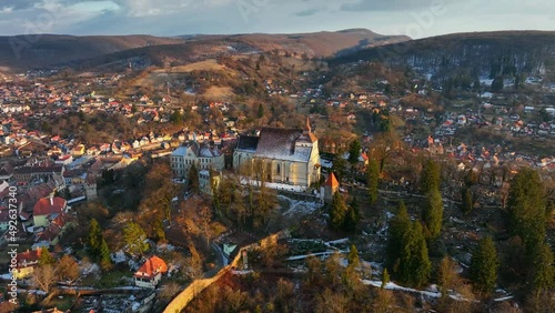 flying above medieval Romanian citadel and old town of Sighisoara, aerial view of famous tourist destination in Romania, scenic unesco heritage site in Transylvania in winter