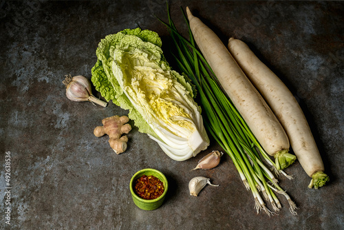Ingredients for kimchi. Fresh vegetables, traditional Korean food in top view on wooden table copy space.