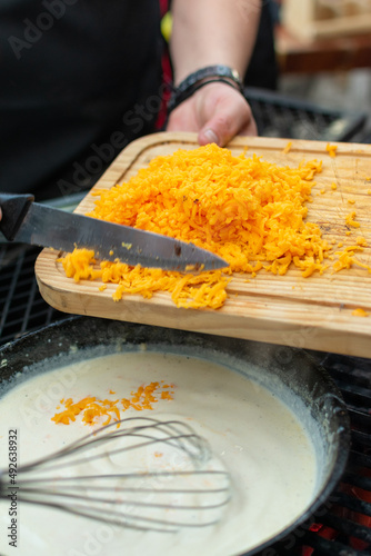 queso cheddar amarillo rallado y agregado en sarten para preparar salsa de quesoqueso cheddarquesocheddar 