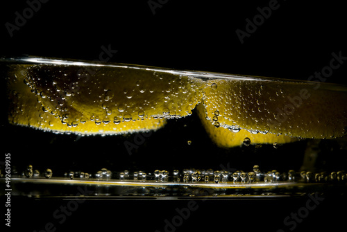 bubbles on yellow lemon in water
