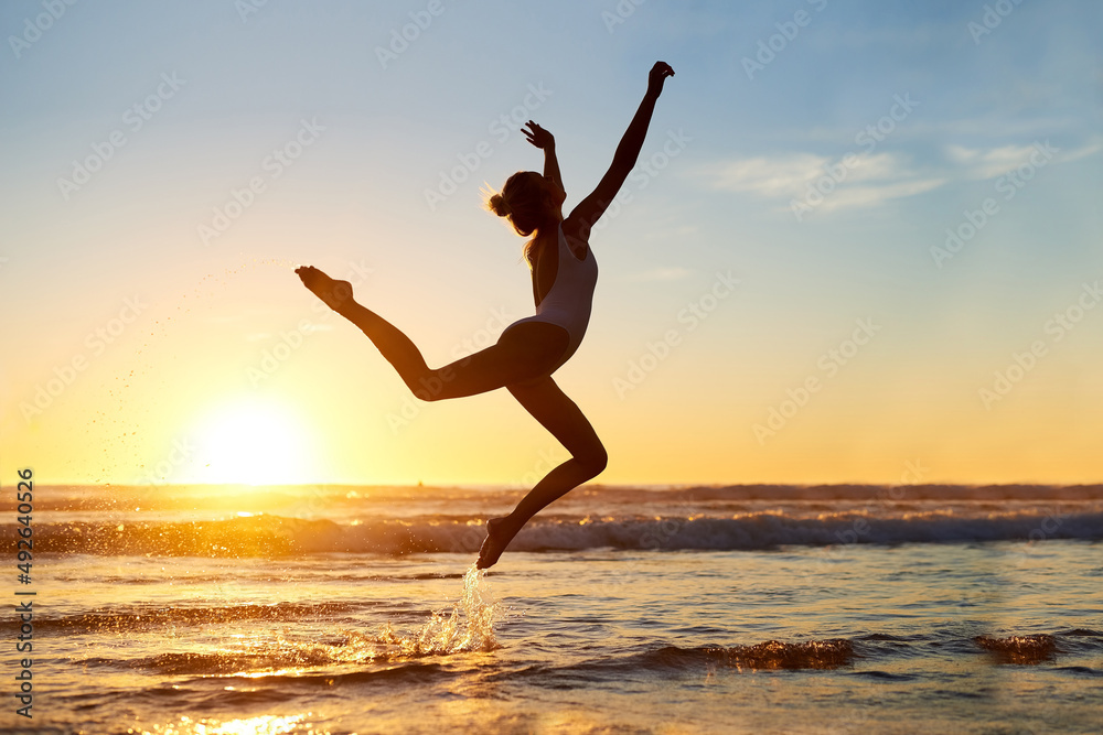 Youre free to be whoever. Shot of a young woman jumping into mid air against a beautiful sunset at the beach. Youre free to be whoever. Shot of a young woman jumping into mid air against a beautiful sunset at the beach.