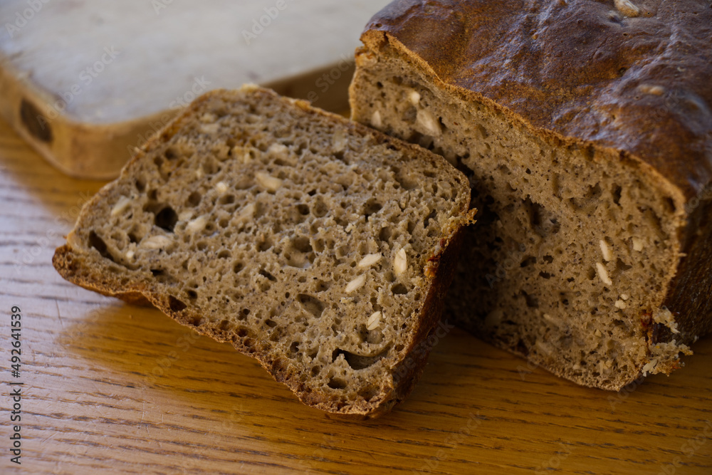 Home made sourdough bread: Fresh, home made bread after baking. Cutting board and wooden table in the background. Home made sourdough bread: Fresh, home made bread after baking. Cutting board and wooden table in the background.