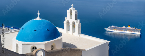 Panoramic view of the Three Bells of Fira with blue domed church, Santorini island, Greece photo