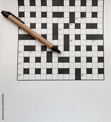 pen made of recycled material lies on empty crossword puzzles top view free space isolated
