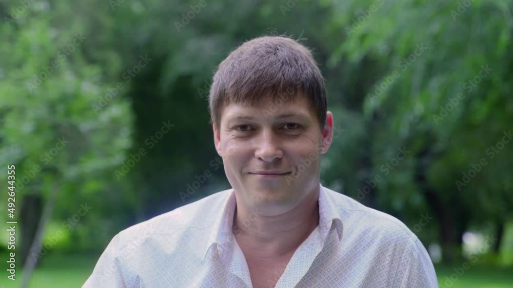 A young guy smiles and laughs in nature in the summer A young guy smiles and laughs in nature in the summer