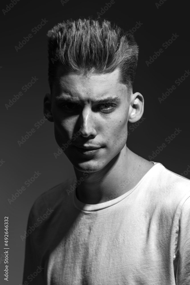 Fototapeta premium Male beauty concept. Portrait of a fashionable young man with stylish haircut. Close up. Copy-space black and white image
