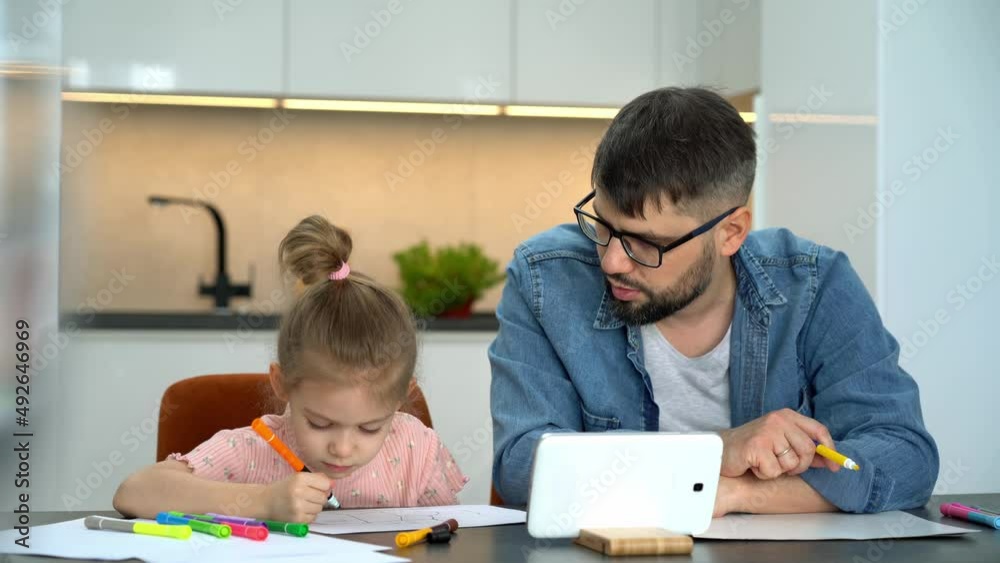 Father and little child learn to draw watching drawing lesson on tablet on internet at home. Online education concept. Video tutorial, drawing training. Father and little child learn to draw watching drawing lesson on tablet on internet at home. Online education concept. Video tutorial, drawing training.