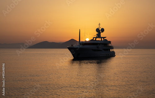 Anchored a luxury motor yacht off the coast of the ITHACA island, KIONI Bay, Ionian Islands, Greece in summer during the sunrise.