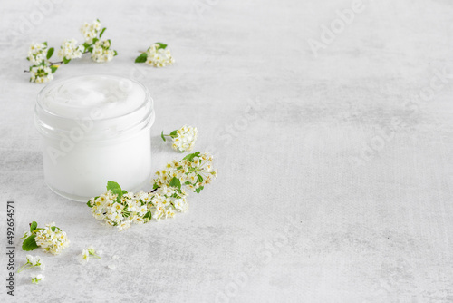 White moisturizing cream cosmetic for spa treatment with blossoms flowers