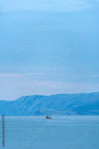Fisherman and fishing boat in Adriatic sea in early morning