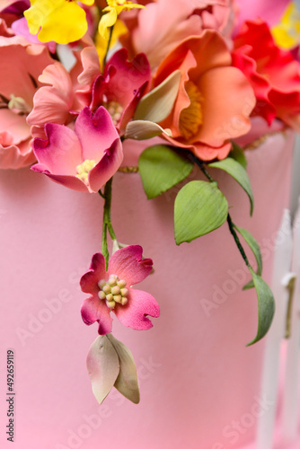 closeup of pink flowers on a branch on the surface of the cake 