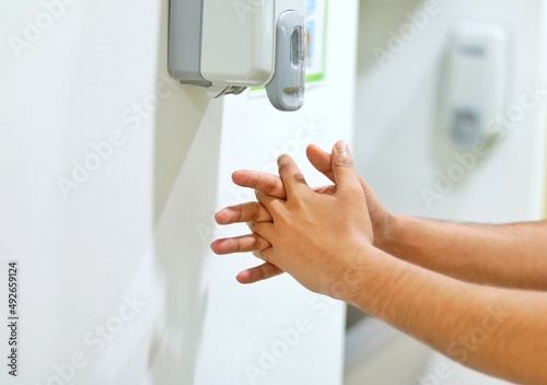 A HEALTHCARE WORKER RUBBING THE FINGERS WITH ALCOHOL BASED HAND RUB.NFECTION CONTROL CONCEPT.