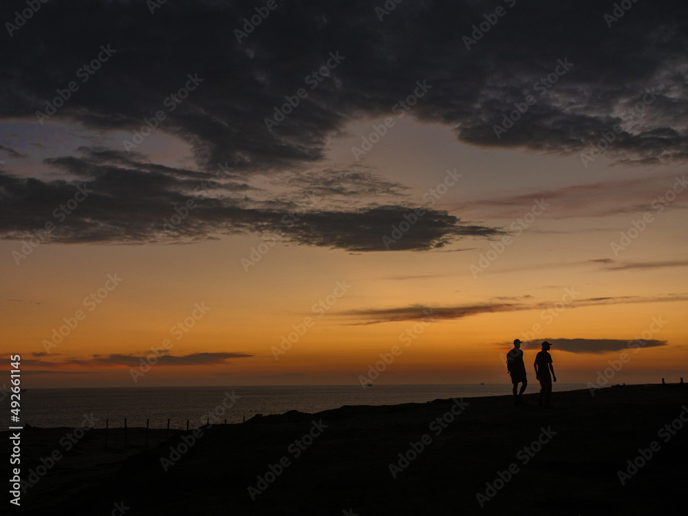 Couple walking on a hill at sunset