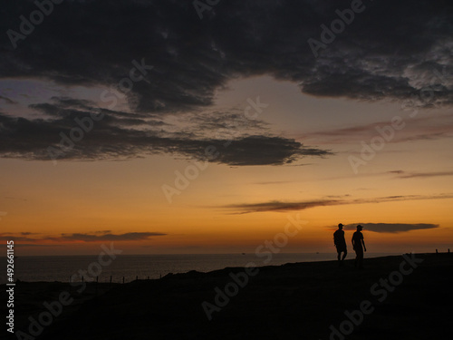 Couple walking on a hill at sunset