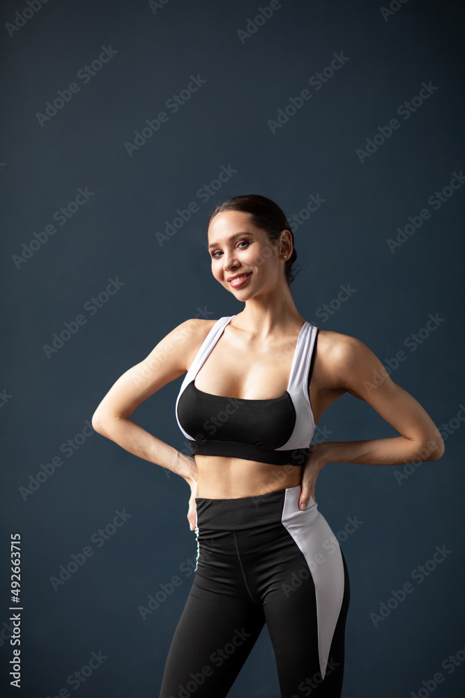 Portrait of a beautiful smiling fitness woman in black and white sportswear Portrait of a beautiful smiling fitness woman in black and white sportswear