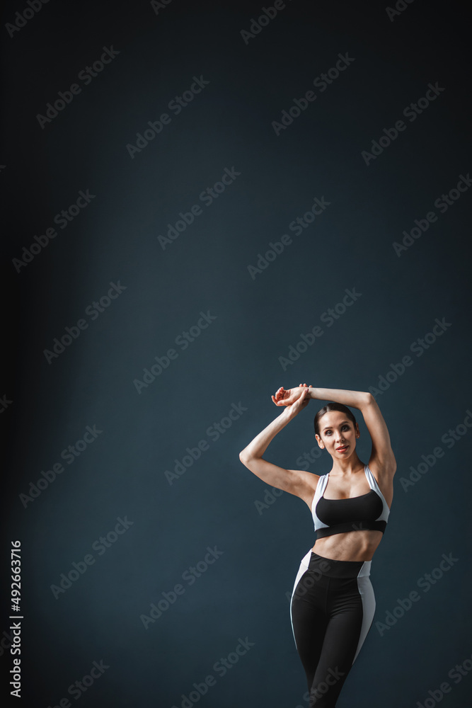 Beautiful fitness woman. Athletic girl standing over blue wall