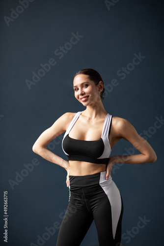 Portrait of a beautiful smiling fitness woman in black and white sportswear