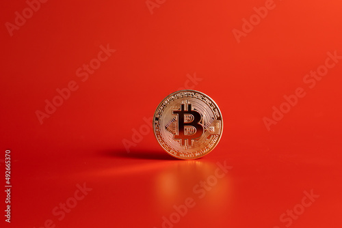 gold bitcoin coin on red background 