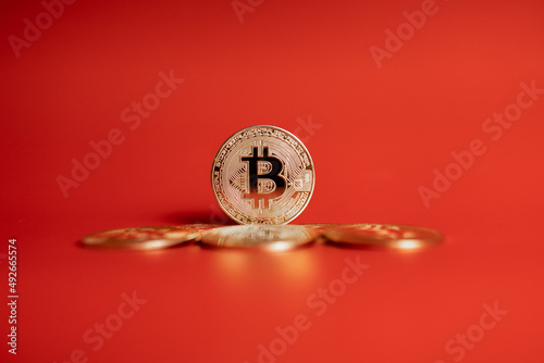 gold bitcoin coins on red background 