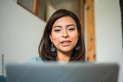 Focused Asian student talking through her computer in class.