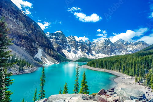 Fototapeta Naklejka Na Ścianę i Meble -  Famous Moraine lake in Banff National Park, Canadian Rockies, Canada. Sunny summer day with amazing blue sky. Majestic mountains in the background. Clear turquoise blue water.