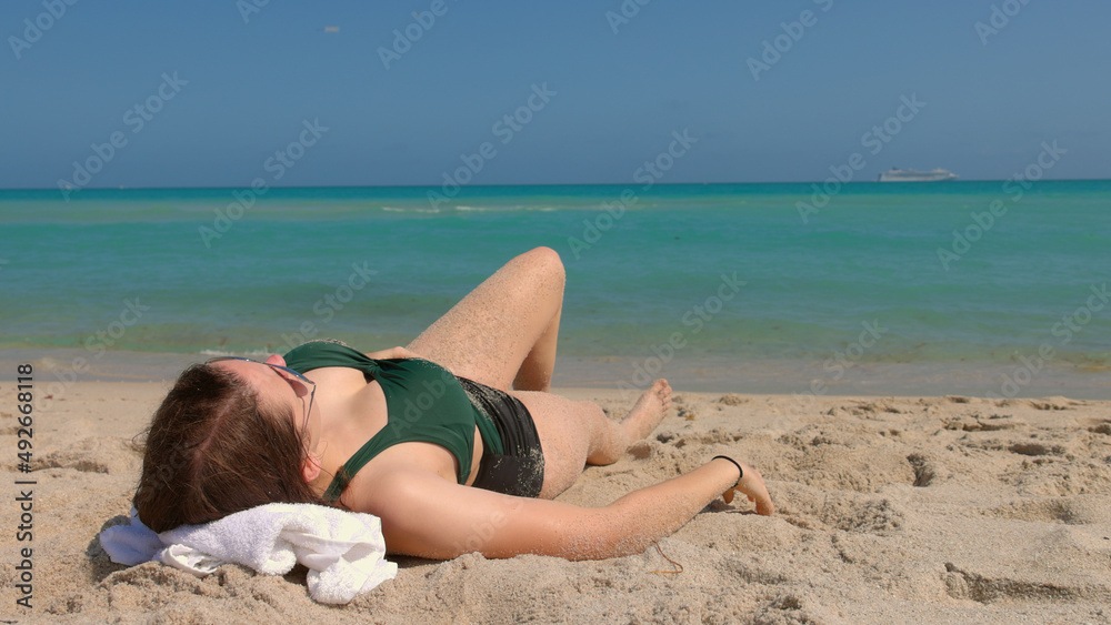 Beautiful woman in a bathing suit enjoys the blue ocean water at Miami Beach Beautiful woman in a bathing suit enjoys the blue ocean water at Miami Beach