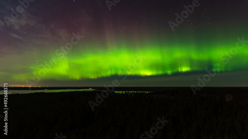 Aurora borealis, The Northern lights at the lake Usma and forest, Latvia. Aerial view.