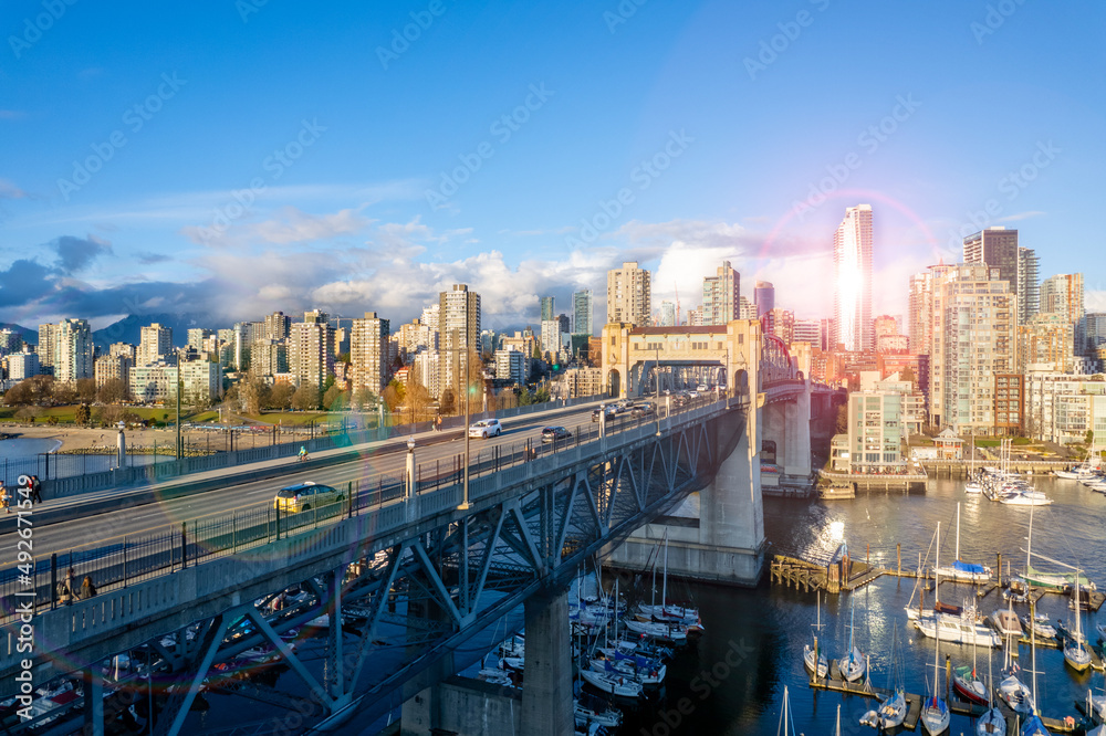 Obraz premium Beautiful view of downtown Vancouver skyline. Aerial photo at sunset of the vibrant city with the iconic Burrard Bridge and Burrard inlet British Columbia, Canada.