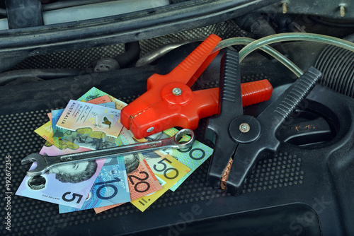 Australian dollar money currency and ring spanner and electricity jumper cables to charging car battery