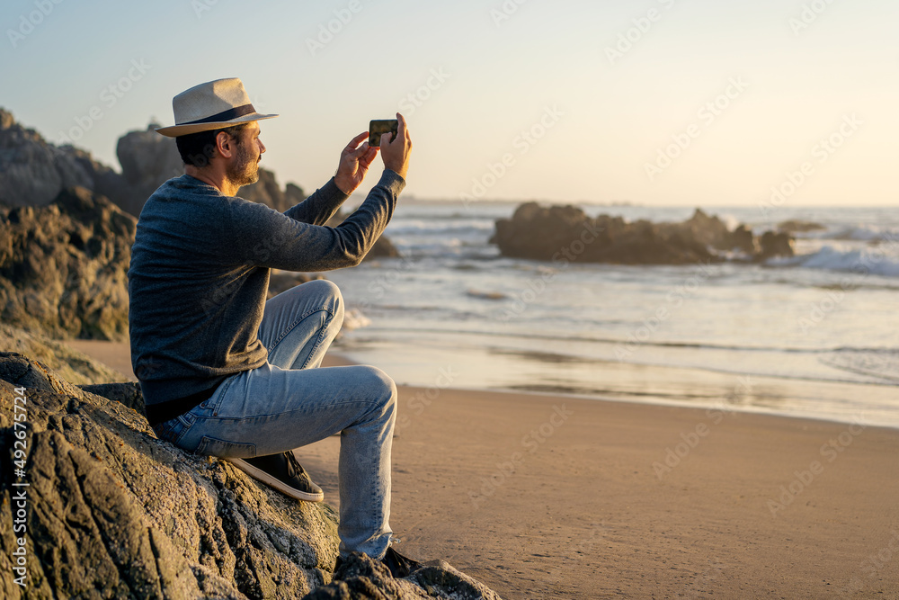 man taking selfies with smartphone and smiling on beach happy.