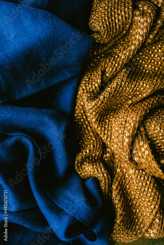 deep, rich jewel tone cobalt blue fabric next to gold sequined cloth scarf