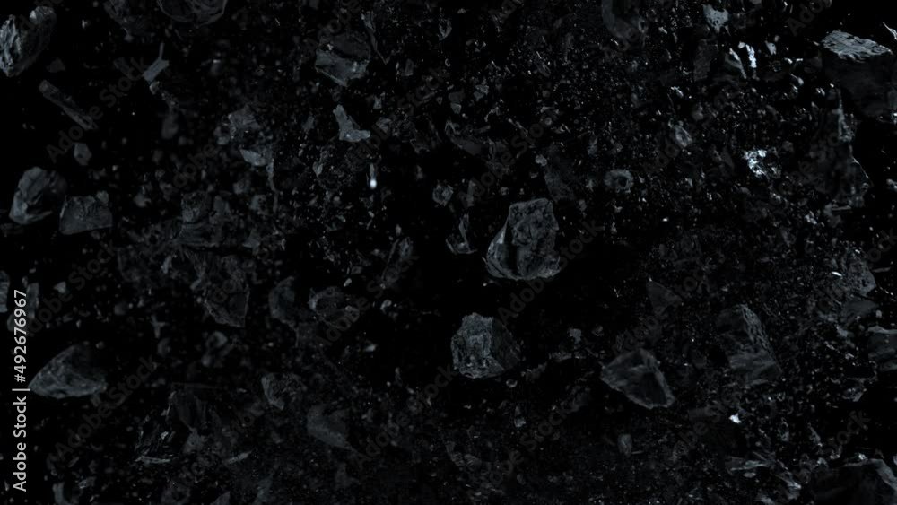 Super slow motion shot of rotating exploded scattered coal on black at 1000fps.