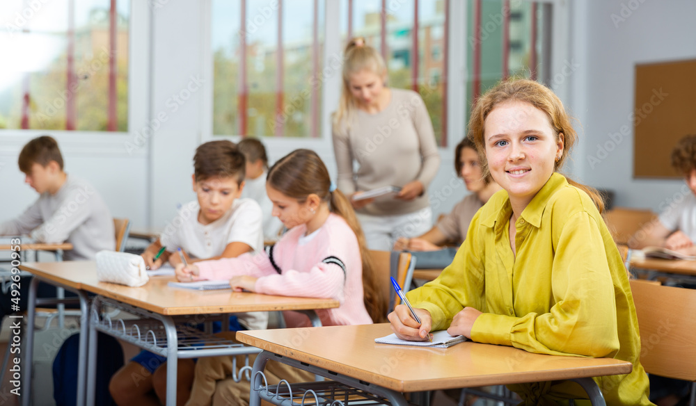 Fototapeta premium Teenage students are sitting at their desks in classroom