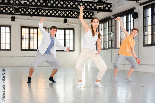 One young lady and three boys dancing modern dance on rehearsal