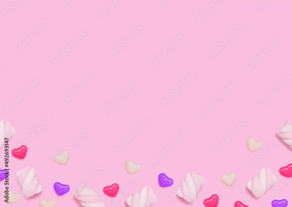 Lollipops and bonbons. Template with copy space. Swirl marshmallows and heart shaped candies on pink backdrop