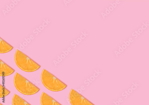 Oranges. Design template with copy space. Slices of ripe orange on pink background. Minimal style.