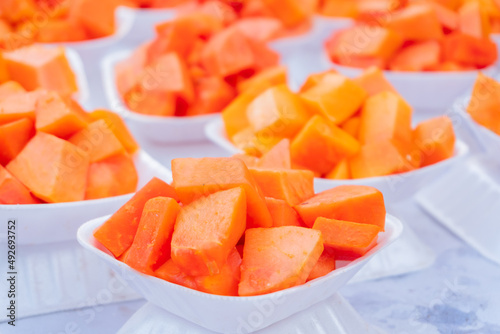 Slices of Papaya fruit - served on small white plates are a popular steet food of local people pf Kolkata. West Bengal - India