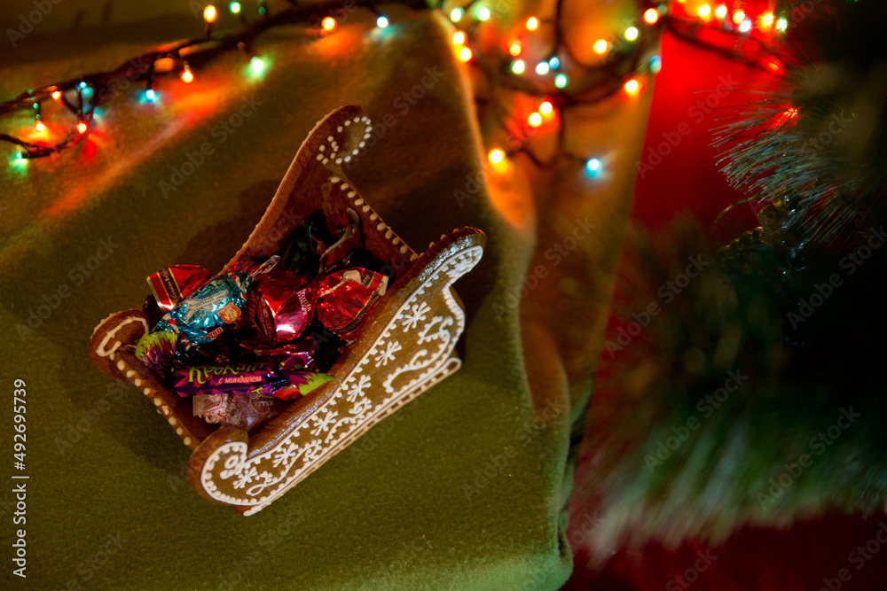 Christmas gingerbread sledges with candies and bokeh light garland. Christmas food. Top View.