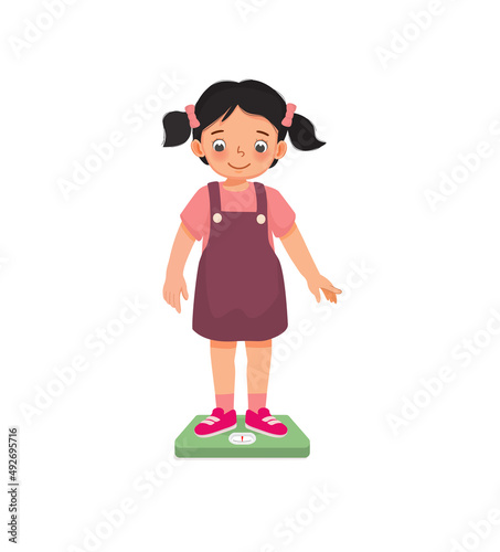 cute little girl child standing on the weighing scale checking her weight