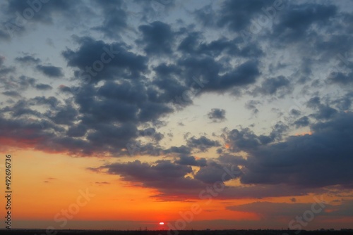 Beautiful orange fiery sunset with dark clouds  natural background 