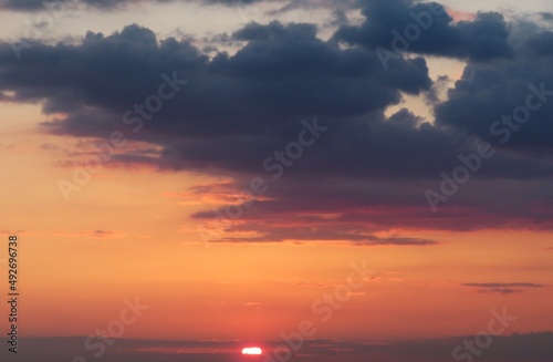 Beautiful orange fiery sunset in the sky with dark clouds © natalya2015